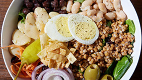 overhead view of farro grain bowl with colorful vegetables and beans