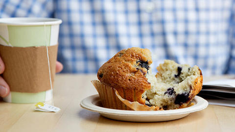 customer at table with tea and muffin