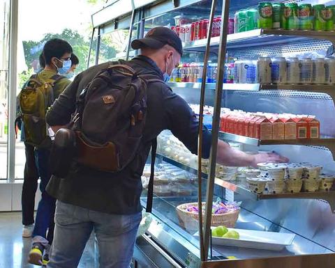 student getting to-go food from SEC Fly By